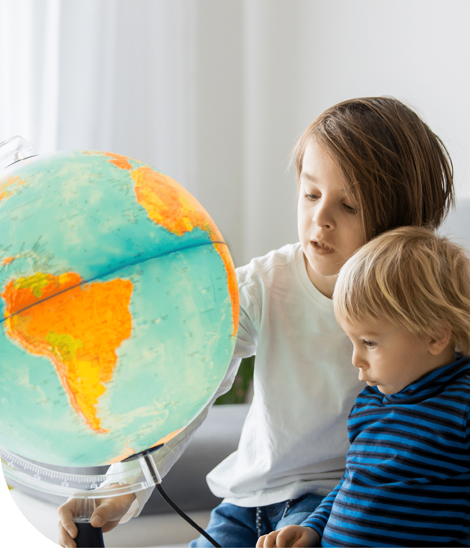 Little children, brothers, looking at illuminated globe, exploring the world, learning